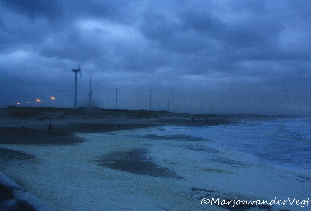 Het schuim hoopt zich op 't strand